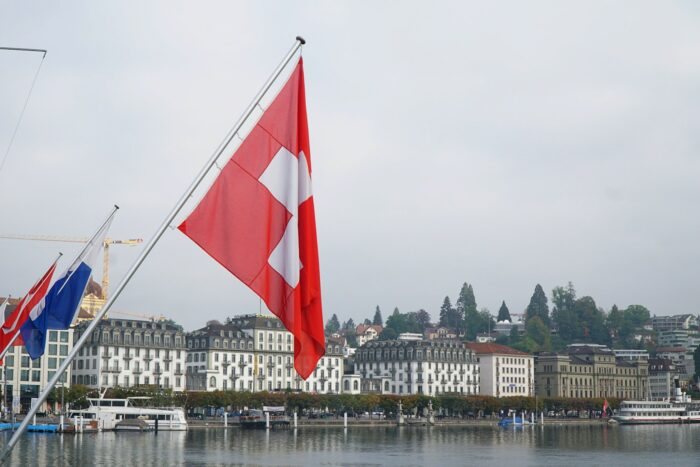 red and white flag on pole near body of water during daytime